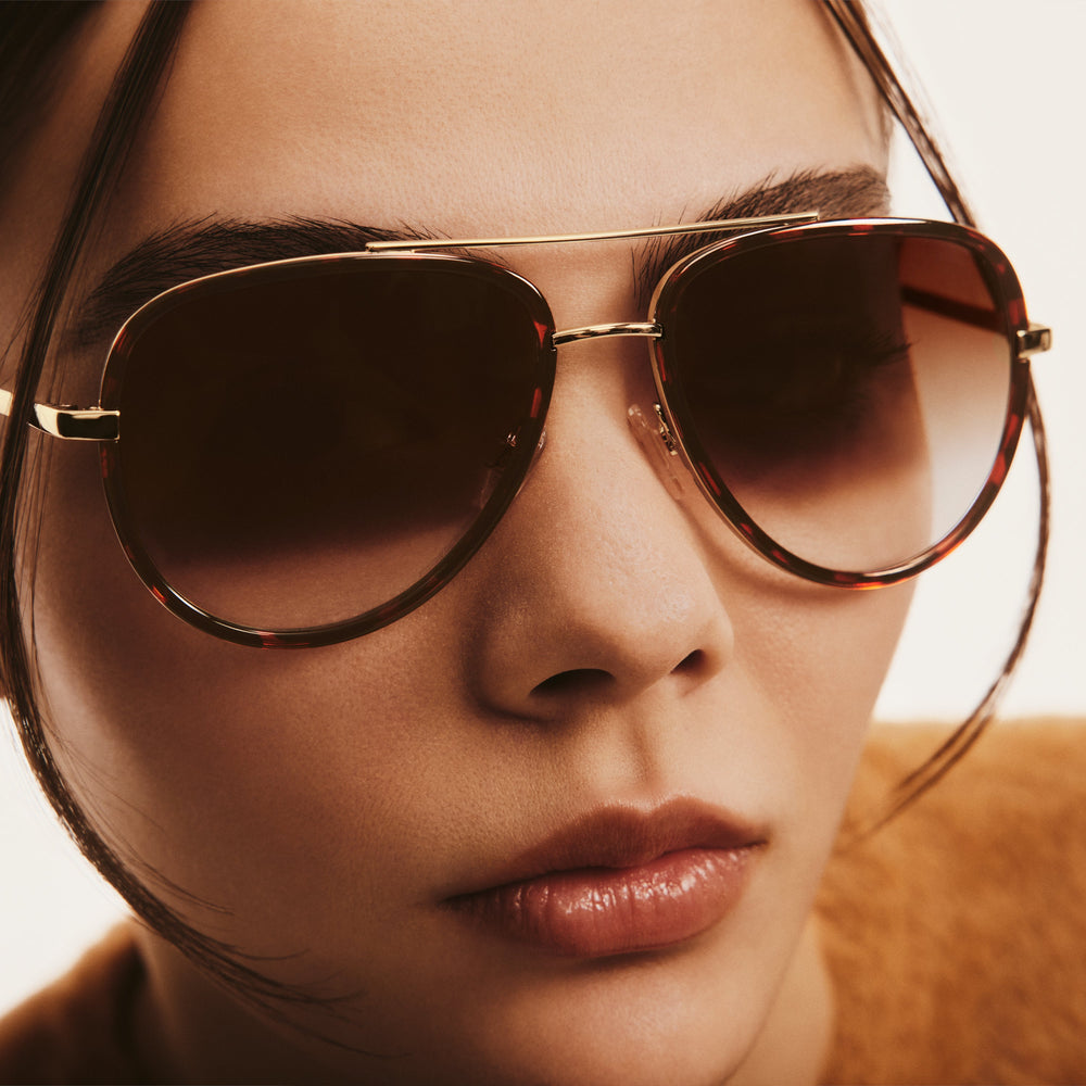 Close up of model wearing QUAY ALL IN MINI small retro aviator sunglasses with tortoise frame and brown gradient lenses